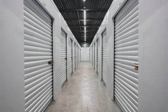 Interior hallway of a self storage facility with white doors.